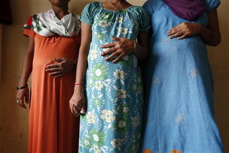 Surrogate mothers (L-R) Daksha, 37, Renuka, 23, and Rajia, 39, pose for a photograph inside a temporary home for surrogates provided by Akanksha IVF centre in Anand town, about 70 km (44 miles) south of the western Indian city of Ahmedabad August 27, 2013. REUTERS/Mansi Thapliyal