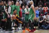 Atlanta Hawks guard Dejounte Murray (5) is fouled by Boston Celtics guard Derrick White (9) during overtime in an NBA basketball game Thursday, March 28, 2024, in Atlanta. (AP Photo/John Bazemore)