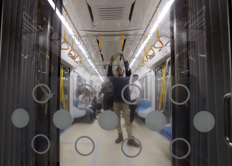 In this Feb. 21, 2019, photo, a man takes a selfie inside Mass Rapid Transit (MRT) during a trial run in Jakarta, Indonesia. Commuting in the gridlocked Indonesian capital will for some involve less frustration, sweat and fumes when its first subway line opens later this month. The 10-mile system running south from Jakarta's downtown is the first phase of a development that if fully realized will plant a cross-shaped network of stations in the teeming city of 30 million people. (AP Photo/Achmad Ibrahim)