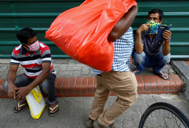 Migrant workers from Bangladesh wear masks as they enjoy a day off on a weekend in Singapore