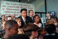 FILE - Muhammad Ali poses with third-graders following a press conference called to announce the development of The Muhammad Ali Center in Louisville, Ky., in this Wednesday, Oct. 7, 1998, file photo. A new documentary looks at the city that raised Muhammad Ali, Louisville, Kentucky, and the week of his funeral, when the community came together to celebrate the legacy of “The Greatest.” (AP Photo/Brian Bohannon, File)