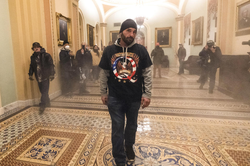 Smoke fills the walkway outside the Senate Chamber as supporters of President Donald Trump, including Doug Jensen, center, are confronted by Capitol Police officers on Jan. 6, 2021. (Manuel Balce Ceneta / AP file)