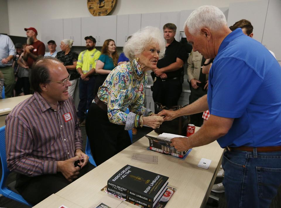 Republican presidential candidate and former vice president Mike Pence signs a book during a campaign stop at Midland Power Cooperative Tuesday, July 4, 2023, in Boone, Iowa.