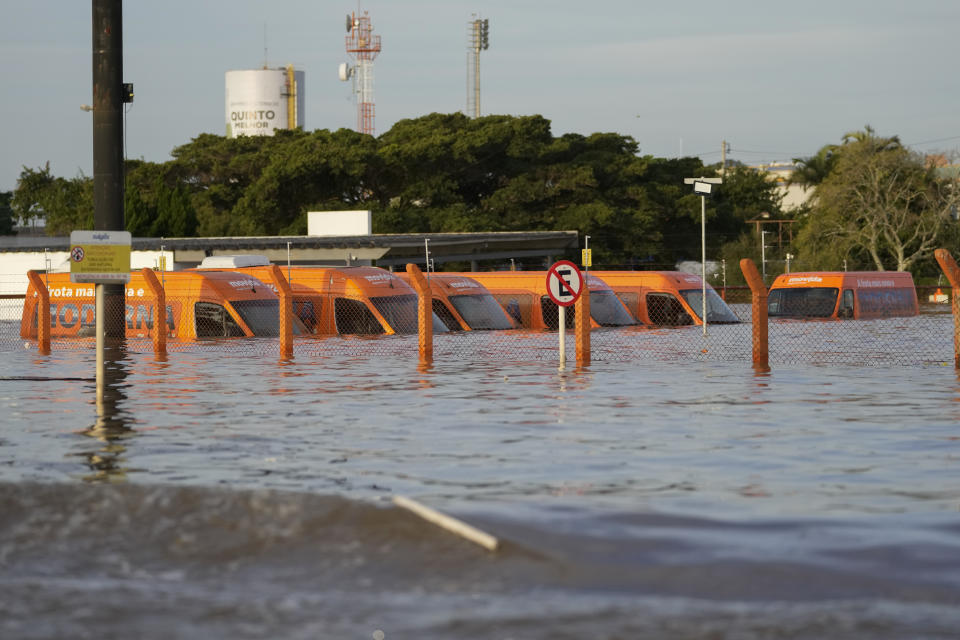 A fleet of vehicles sit partially submerged in flood waters caused by heavy rains, in a parking lot near the international airport in Porto Alegre, Brazil, Tuesday, May 7, 2024. (AP Photo/Andre Penner)