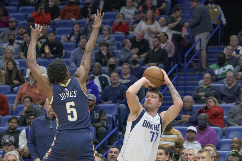 Dallas Mavericks guard Luka Doncic (77) shoots against New Orleans Pelicans forward Herbert Jones (5) during the first half of an NBA basketball game in New Orleans, Wednesday, Dec. 1, 2021. (AP Photo/Matthew Hinton)