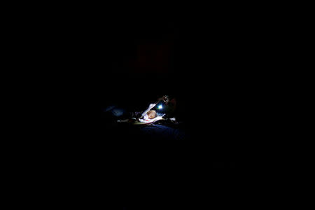 A woman prepares to sleep on the floor next to her baby in a partially destroyed school used as a shelter after Hurricane Matthew hit Jeremie, Haiti, October 11, 2016. REUTERS/Carlos Garcia Rawlins/File Photo