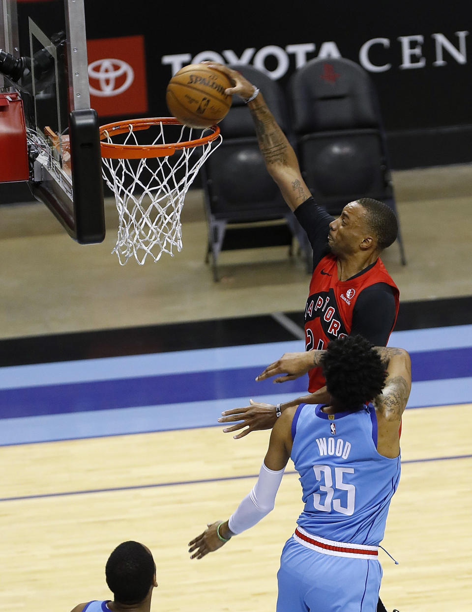 Toronto Raptors' Norman Powell (24) dunks next to Houston Rockets' Christian Wood (35) during the first quarter of an NBA basketball game Monday, March 22, 2021, in Houston. (Bob Levey/Pool Photo via AP)