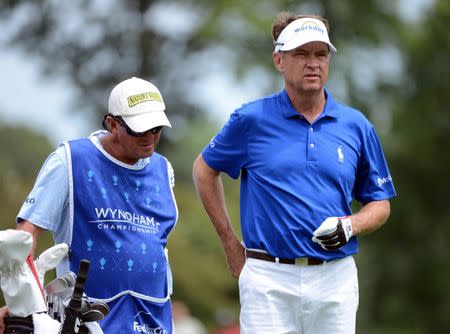 Aug 23, 2015; Greensboro, NC, USA; Davis Love III (right) studies his approach shot on the 1st hole during the final round of the Wyndham Championship golf tournament at Sedgefield Country Club. Rob Kinnan-USA TODAY Sports