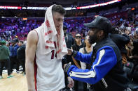Miami Heat guard Tyler Herro, left, talks with former boxer Floyd Mayweather Jr. after an NBA basketball game between the Heat and Charlotte Hornets, Tuesday, April 5, 2022, in Miami. The Heat won 144-115. (AP Photo/Lynne Sladky)