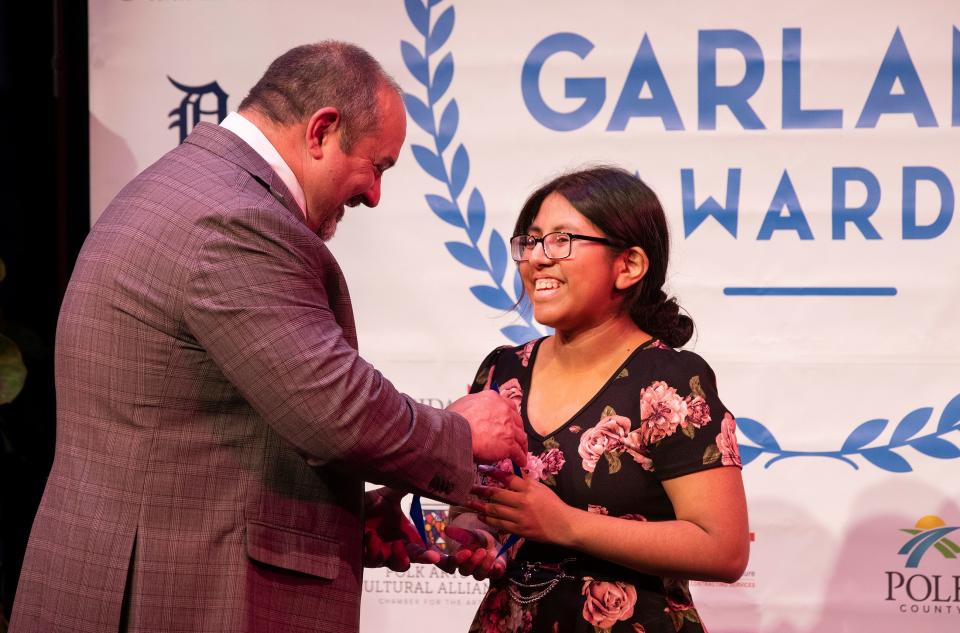 Superintendent of Schools Frederick Heid presents Leticia Hernandez-Bautista of Fort Meade High School with the Silver Garland Award for Foreign Language.