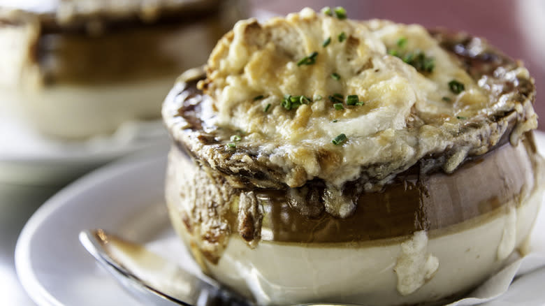 French onion soup in brown and white bowl