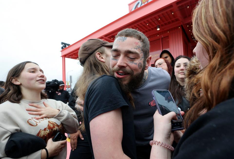A fan hugs Post Malone during the grand opening celebration of a Raising Cane’s Restaurant, designed by the singer, in Midvale on Thursday, April 13, 2023. | Kristin Murphy, Deseret News