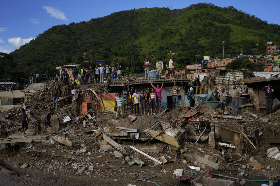 Locals cheers Venezuela's President Nicolas Maduro as he visits the flood damaged area in Las Tejerias, Venezuela, Monday, Oct. 10, 2022. A fatal landslide fueled by flooding and days of torrential rain swept through this town in central Venezuela. (AP Photo/Matias Delacroix)