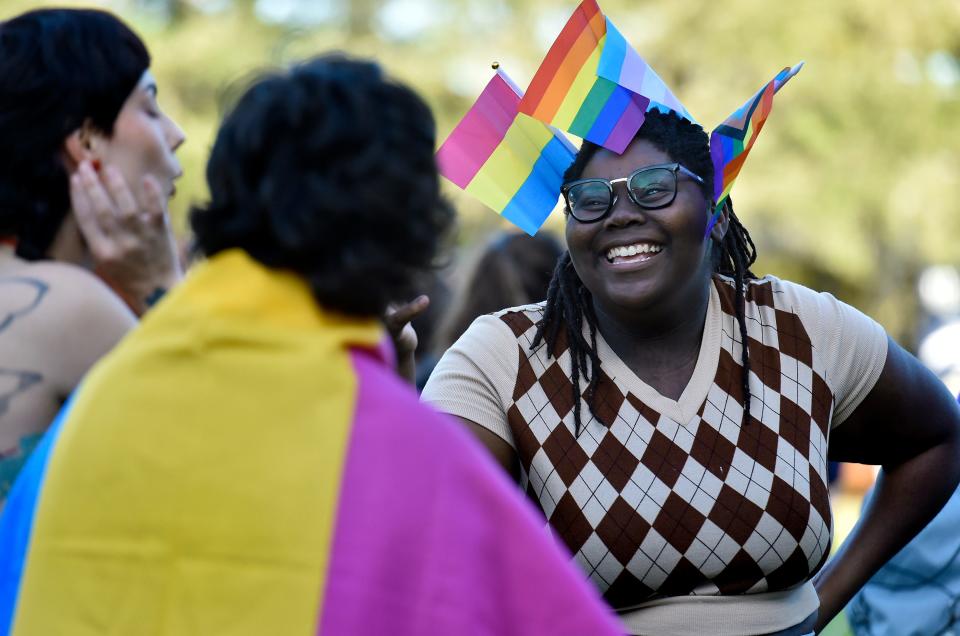 A UNF student talks with friends prior to a Jan. 24 rally at the university's Fine Arts Center. About 100 students rallied on the lawn there to protest the closure of the school's LGBTQ center to comply with state law that bans diversity spending.