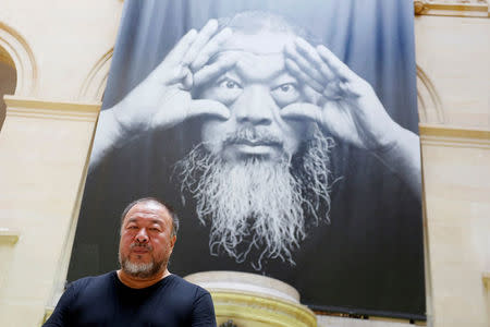 Chinese artist and free-speech advocate Ai Weiwei poses under the poster of an exhibition titled "Ai Weiwei: By the way, it's always the others" at the Musee Cantonal des Beaux Arts in Lausanne, Switzerland September 20 2017. REUTERS/Pierre Albouy