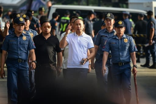 Philippine congressman Esmael Mangudadatu (white shirt) is escorted by security personnel to hear the verdict. His decision to run for governor and challenge the Ampatuan family led to the massacre of 58 people, including his wife and two sisters