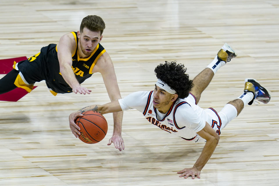 Illinois guard Andre Curbelo (5) dives to make a steal under Iowa guard Jordan Bohannon (3) in the second half of an NCAA college basketball game at the Big Ten Conference tournament in Indianapolis, Saturday, March 13, 2021. (AP Photo/Michael Conroy)