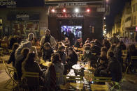 Friends gather at a bar before curfew in Marseille, southern France, Saturday, Oct. 17, 2020. France is deploying 12,000 police officers to enforce a new curfew that came into effect Friday night for the next month to slow the virus spread, and will spend another 1 billion euros to help businesses hit by the new restrictions. (AP Photo/Daniel Cole)