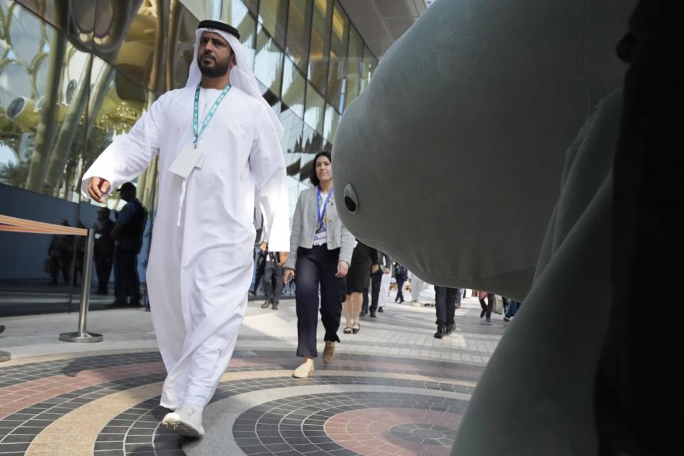 A dugong costume, right, is transported at the COP28 U.N. Climate Summit, Wednesday, Dec. 6, 2023, in Dubai, United Arab Emirates. (AP Photo/Peter Dejong)
