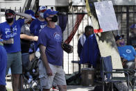 Chicago Cubs fans wait for a ball outside of Wrigley Field before the Opening Day baseball game between the Chicago Cubs and the Milwaukee Brewers in Chicago, Friday, July 24, 2020, in Chicago. In a normal year, that would mean a sellout crowd at Wrigley Field and jammed bars surrounding the famed ballpark. But in a pandemic-shortened season, it figures to be a different atmosphere. (AP Photo/Nam Y. Huh)