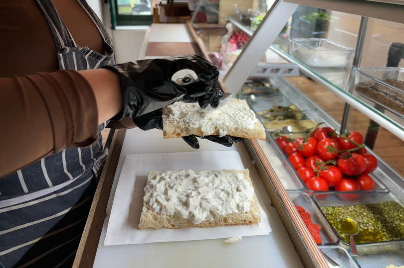 The stracciatella cheese is added to both slices of bread