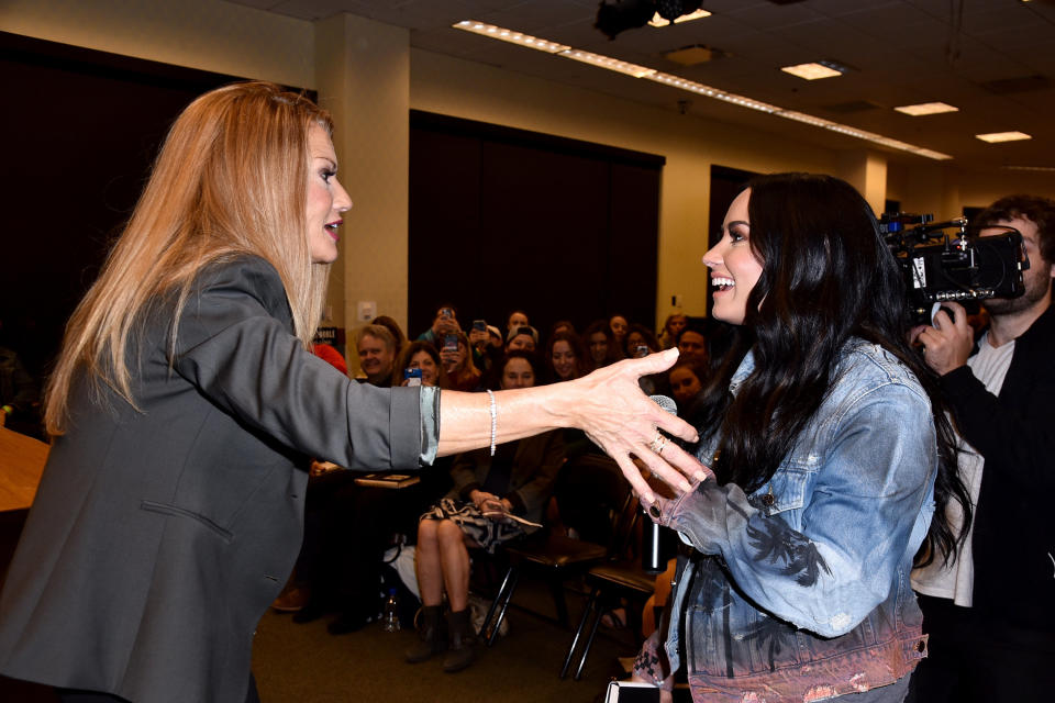 Demi Lovato (R) surprises her mother, author Dianna De La Garza, at her book signing of 'Falling with Wings." (Photo: Brandon Williams via Getty Images)