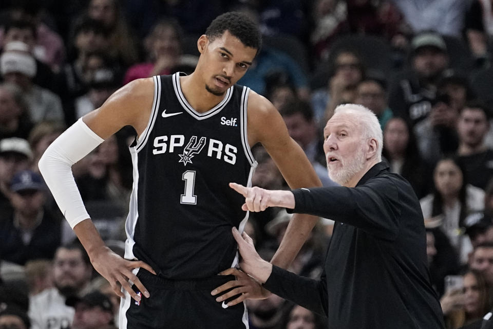 San Antonio Spurs head coach Gregg Popovich, right, talks with center Victor Wembanyama (1) during the first half of an NBA basketball game against the Los Angeles Lakers in San Antonio, Wednesday, Dec. 13, 2023. (AP Photo/Eric Gay)