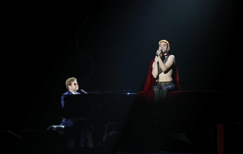 Olly Alexander performs wearing Harris Reed with Elton John at the Brit Awards (via REUTERS)