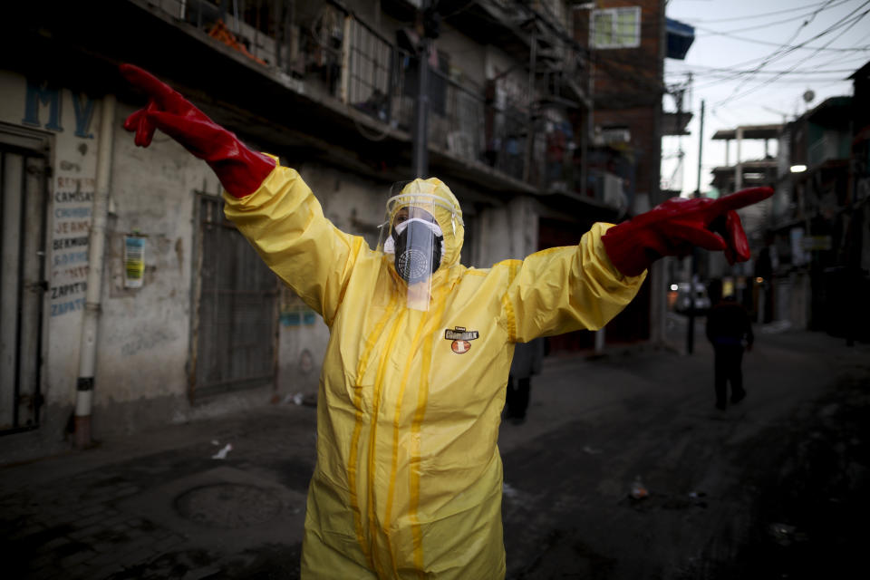 Jimena Aballe dirige a sus vecinos mientras desinfectan sus propias calles para evitar más contagios por coronavirus en la barriada Villa 31 en Buenos Aires, Argentina, el lunes 18 de mayo de 2020. (AP Foto/Natacha Pisarenko)