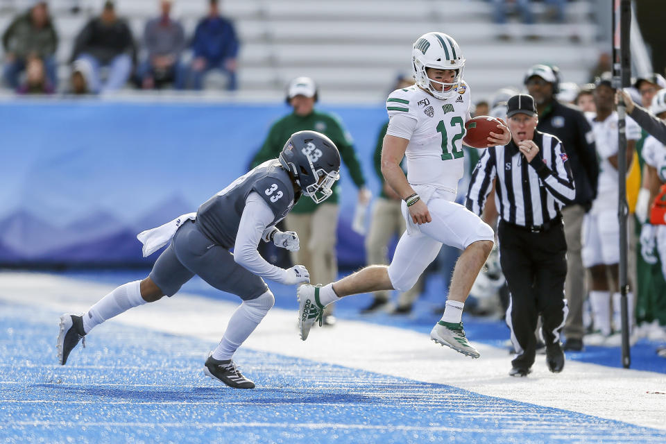 Ohio quarterback Nathan Rourke (12) runs out of bounds with the ball as Nevada defensive back JoJuan Claiborne (33) closes in during the first half of the Famous Idaho Potato Bowl NCAA college football game Friday, Jan. 3, 2020, in Boise, Idaho. (AP Photo/Steve Conner)