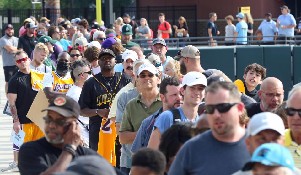 People wait in line to see Magic Johnson Friday afternoon, September 9, 2022, prior to the Honey Hunter’s game at CaroMont Health Park.