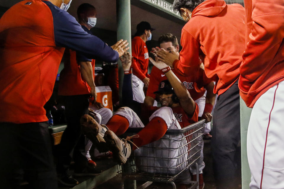 Boston Red Sox's Xander Bogaerts goes for a ride in a shopping cart as he is congratulated by teammates after hitting a three-run home run against the Toronto Blue Jays during the fourth inning of a baseball game Tuesday, April 20, 2021, at Fenway Park in Boston. (AP Photo/Winslow Townson)