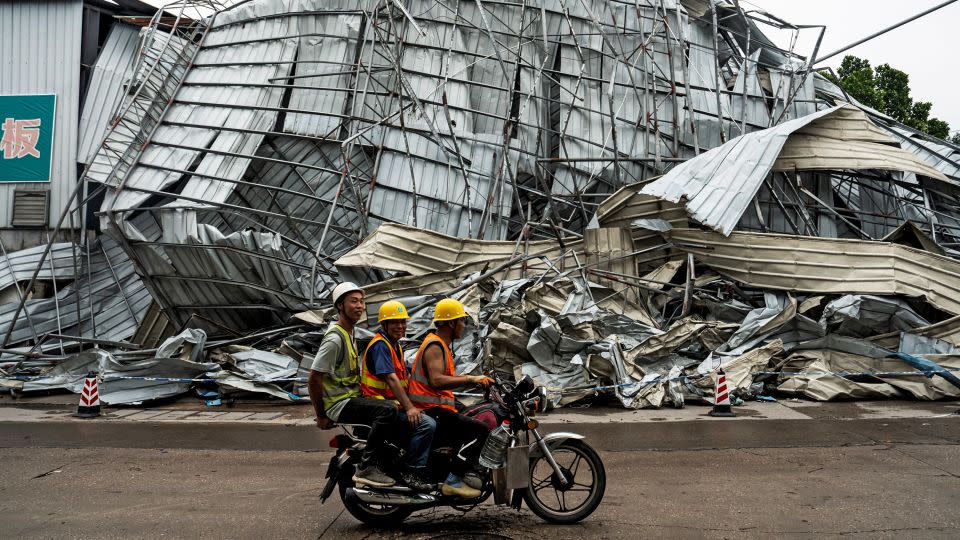 People drive past a damaged building on Sunday after the tornado hit southern China's Guangdong province. - STR/AFP/Getty Images