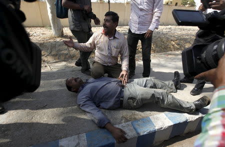 An employee of the Pakistan International Airlines (PIA) reacts after one of his colleagues was wounded by a gunfire during a protest in Karachi, Pakistan, February 2, 2016. REUTERS/Akhtar Soomro