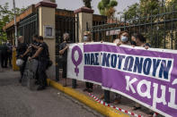 Protesters take part in a rally against domestic violence outside a court house where helicopter pilot Babis Anagnostopoulos is giving evidence after being charged with the murder of his British-Greek wife, in Athens, Tuesday, June 22, 2021. Anagnostopoulos was charged last Friday with the murder of Caroline Crouch, 20, whose death he had initially claimed was caused by burglars during a brutal invasion of their home on the outskirts of Athens. (AP Photo/Petros Giannakouris)