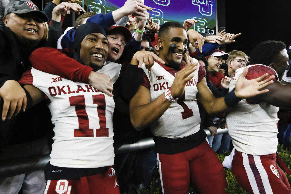 FILE - In this Nov. 16, 2019, file photo, Oklahoma cornerback Parnell Motley, left, and quarterback Jalen Hurts, right, celebrate with fans following an NCAA college football game against Baylor, in Waco, Texas. Motley and Hurts were selected to The Associated Press All-Big 12 Conference team, Friday, Dec. 13, 2019. (AP Photo/Ray Carlin, File)