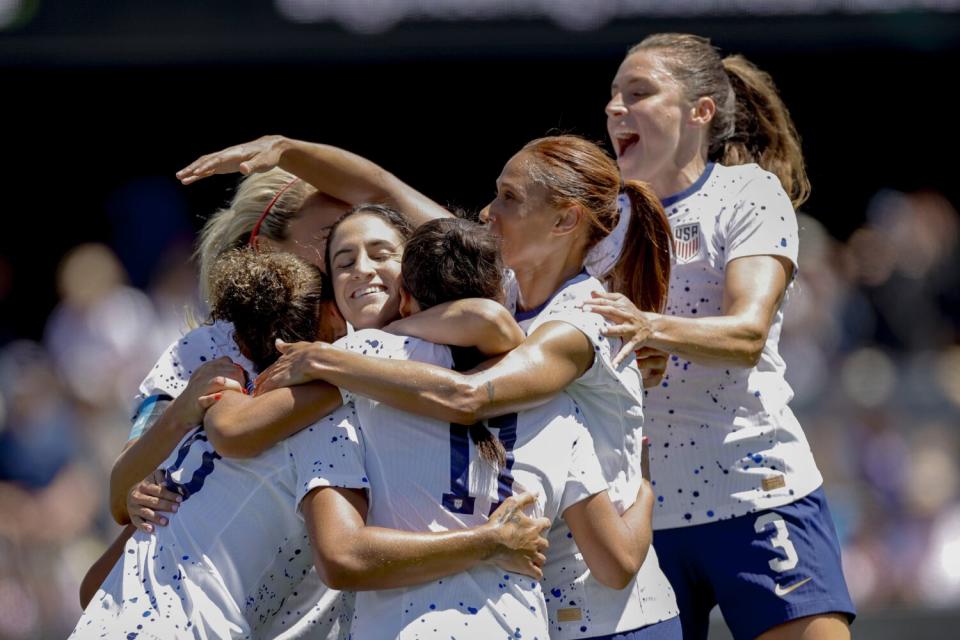 Trinity Rodman (20) celebrates with teammates, including Savannah DeMelo (9) and Kristie Mewis (22).