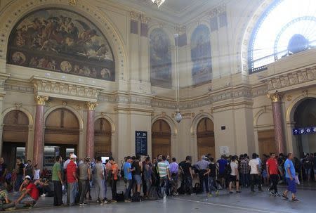 People stand in a queue to buy train tickets a the railway station in Budapest, Hungary, August 31, 2015. REUTERS/Bernadett Szabo