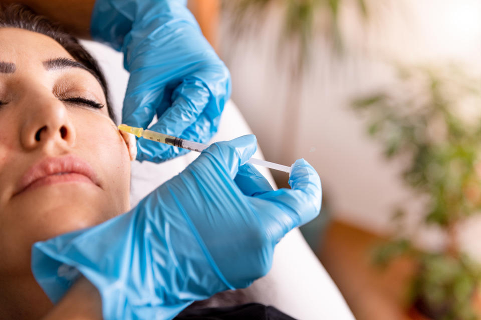 Mature woman receiving fillers in face for crepey skin.