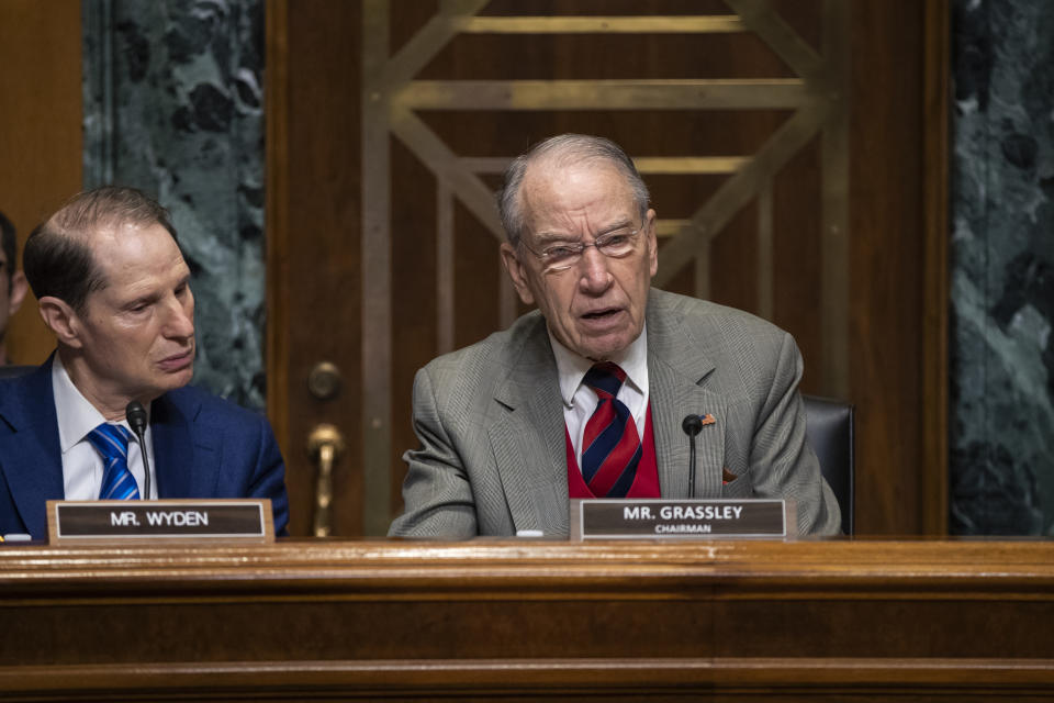 FILE - In this Tuesday, Jan. 29, 2019, file photo, Sen. Chuck Grassley, R-Iowa, center, chairman of the Senate Finance Committee, is joined at left by Sen. Ron Wyden, D-Ore., the ranking member, at a hearing on the high price of prescription drugs, on Capitol Hill in Washington. A bipartisan congressional investigation released Wednesday, Dec. 16, 2020, by Grassley and Wyden, found that key players in the nation’s opioid industry have spent $65 million since 1997 funding nonprofits that advocate treating pain with medications, a strategy intended to boost the sale of prescription painkillers. (AP Photo/J. Scott Applewhite, File)