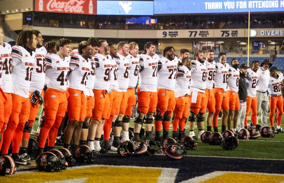 Oct 21, 2023; Morgantown, West Virginia, USA; Oklahoma State Cowboys players celebrate after defeating the West Virginia Mountaineers at Mountaineer Field at Milan Puskar Stadium. Mandatory Credit: Ben Queen-USA TODAY Sports