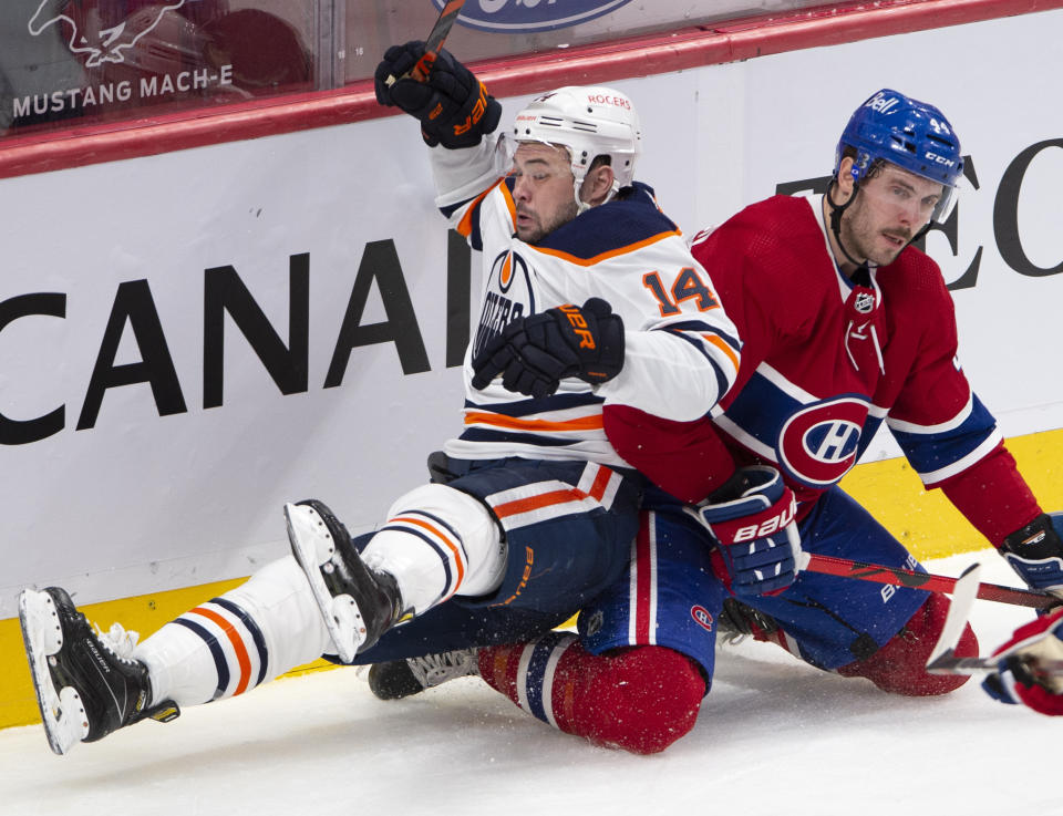 Montreal Canadiens' Joel Edmundson (44) checks Edmonton Oilers' Devin Shore (14) during second-period NHL hockey game action in Montreal, Monday, May 10, 2021. (Ryan Remiorz/The Canadian Press via AP)