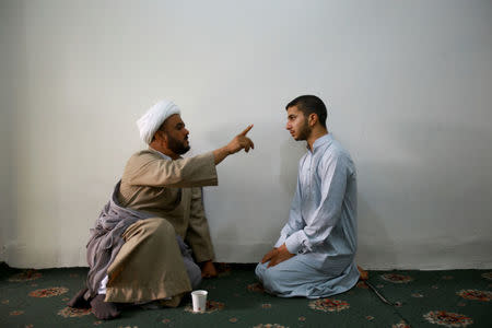 A Shi'ite cleric (L) speaks to a student at Ibn al-Fahd al-Heli school run by al-Hawza al-Ilmiyya in Kerbala, Iraq, August 4, 2017. For more than 1,000 years, the al-Hawza al-Ilmiyya in southern Baghdad has been giving religious instructions to thousands of Shi'ite Muslims to help them become clerics. REUTERS/Abdullah Dhiaa Al-deen