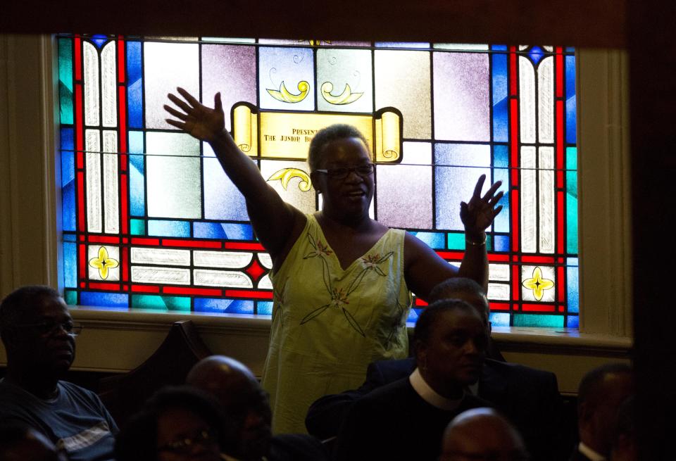 A parishioner prays during a memorial service at Morris Brown AME Church for the people killed Wednesday during a prayer meeting inside a historic black church in Charleston, S.C., Thursday, June 18, 2015. Police arrested 21-year-old suspect Dylann Storm Roof Thursday in Shelby, N.C. without resistance. (AP Photo/David Goldman)