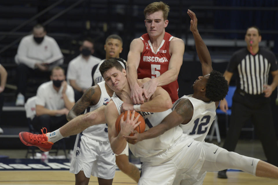 Penn State's John Harrar, center, gets tangled up with teammate Izaiah Brockington (12) as Wisconsin's Tyler Wahl (5) fouls him from behind in the second half of an NCAA college basketball game, Saturday, Jan. 30, 2021, in State College, Pa. (AP Photo/Gary M. Baranec)