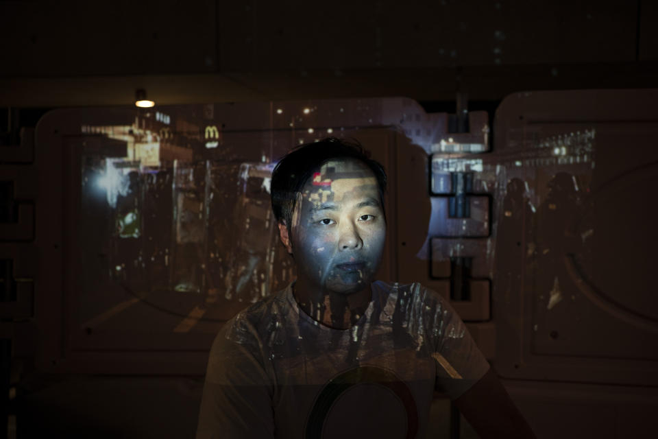 Wong Ho poses for a portrait next to a barricade as a projector displays a photograph, previously taken during the unrest, over him at a protest in Hong Kong. For more than five months, protesters have led a mass movement that prompted the Hong Kong government to withdraw a controversial extradition bill. Following this victory, they have persisted in advocating for their four remaining demands, including calls for democratic reforms and an independent probe into police tactics. (Photo: Felipe Dana/AP)