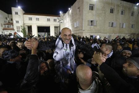 A prisoner (C) released from an Israeli prison is welcomed by relatives in the West Bank city of Ramallah early December 31, 2013. REUTERS/Mohamad Torokman