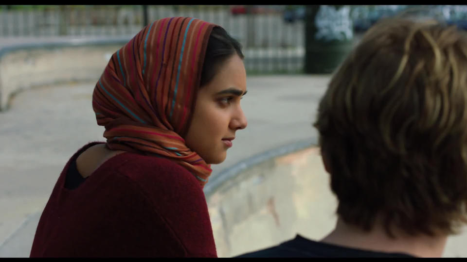 Hala sits next to a young man.