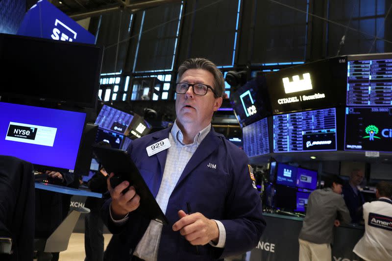 FILE PHOTO: Traders work on the floor of the NYSE in New York