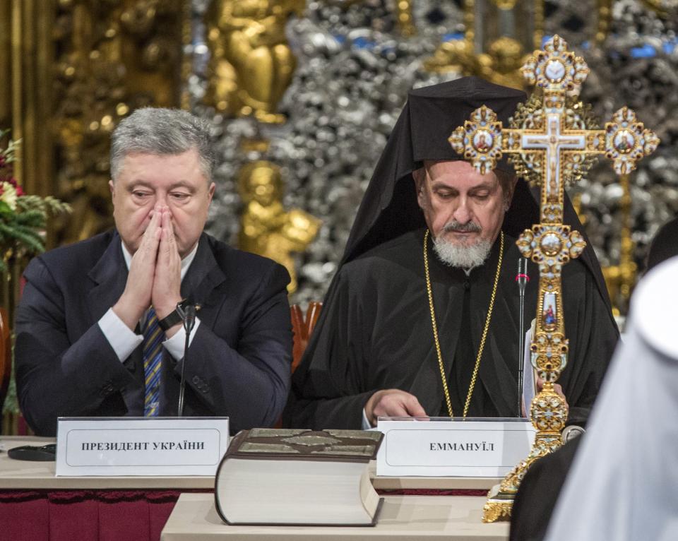 Ukrainian President Petro Poroshenko, left, and Metropolitan Emmanuel attend a closed-door synod of three Ukrainian Orthodox churches to approve the charter for a unified church and to elect leadership in the St. Sophia Cathedral in Kiev, Ukraine, Saturday, Dec. 15, 2018. Poroshenko has told the crowd "the creation of our Church is another declaration of Ukraine's independence and you are the main participants of this historic event." (Mykhailo Markiv, Ukrainian Presidential Press Service/Pool Photo via AP)